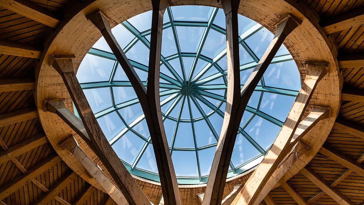 View of the impressive glass dome at the Solemar thermal spa in Bad Dürrheim, framed by wooden beams.