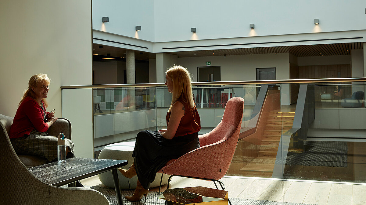 Modern atrium with seating area and two people in conversation