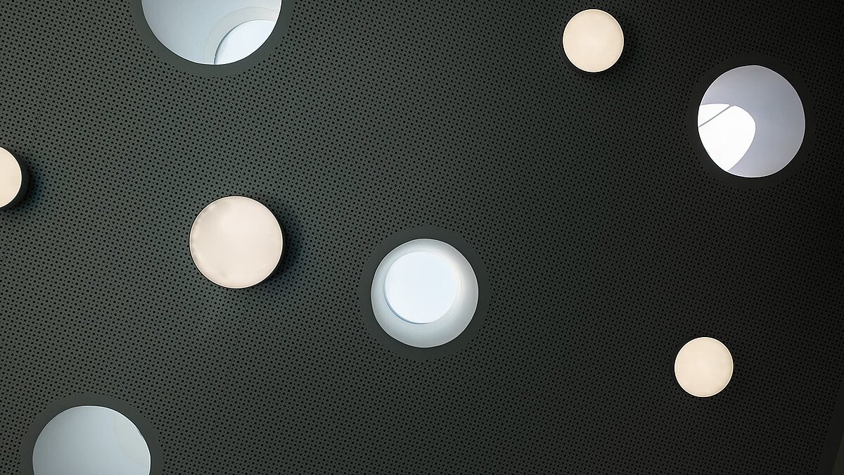 Round skylights and lights in the perforated ceiling of the Sonnenfeld daycare center in Wandlitz.