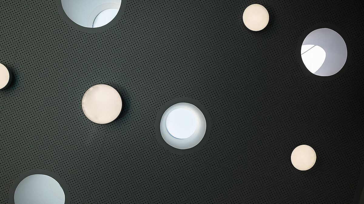 Round skylights and lights in the perforated ceiling of the Sonnenfeld daycare center in Wandlitz.