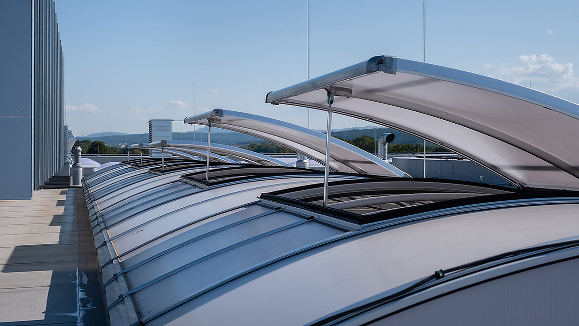 Open skylight domes on the flat roof of an industrial building