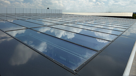 Glass roof of the commercial building in Milton Park, England, reflecting the sky and clouds on its surface.