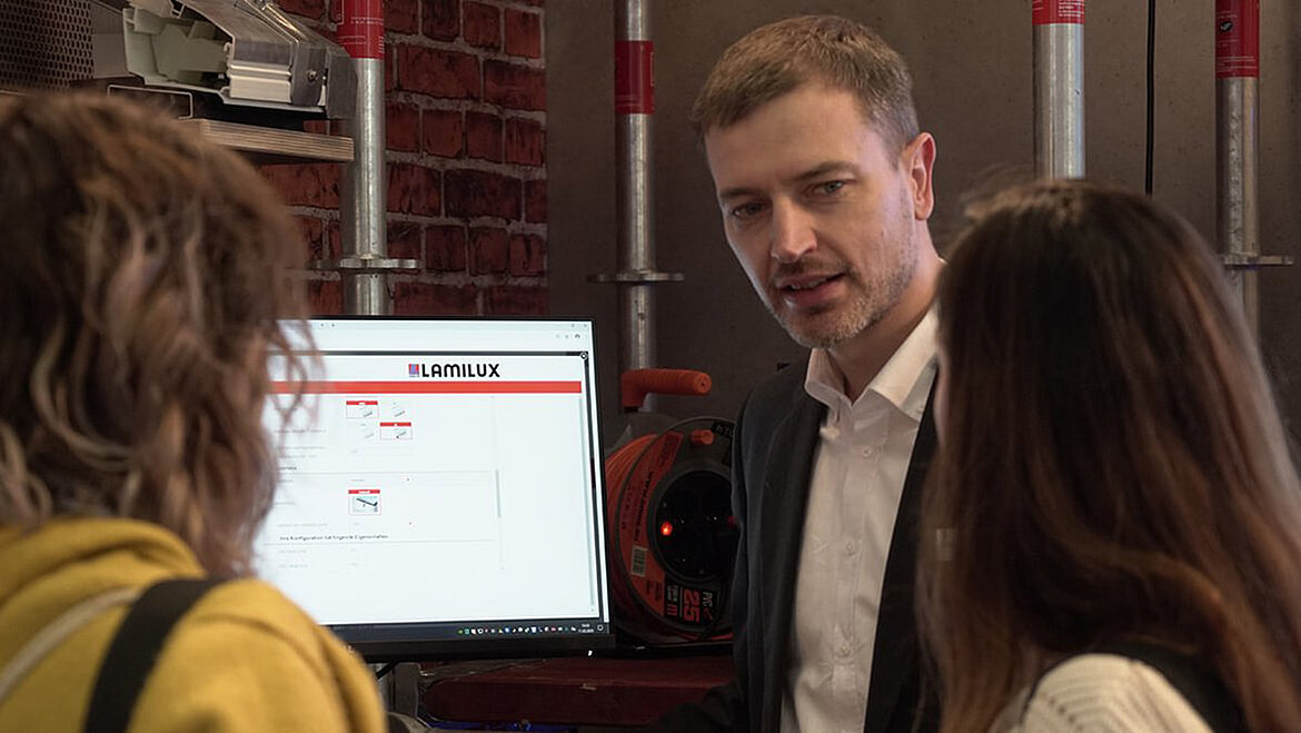 Carste Ficker explains LAMILUX planning support to two women on a monitor