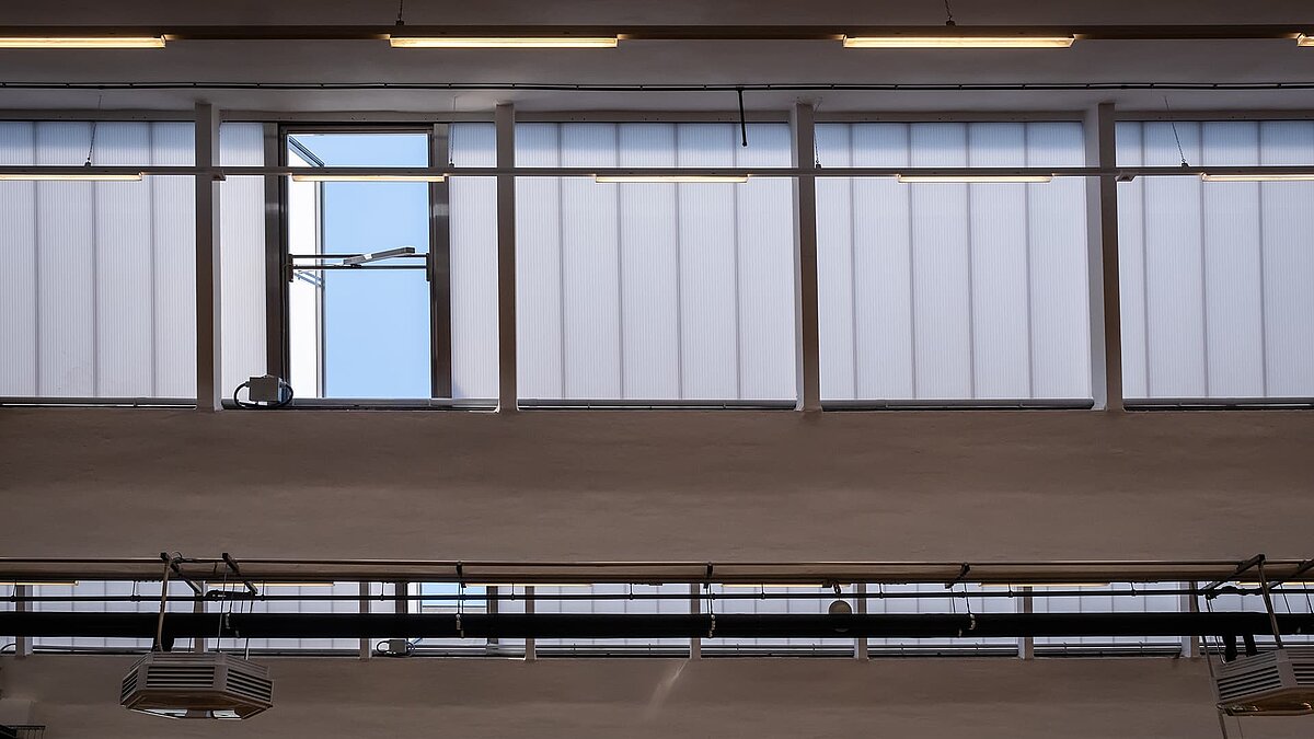 Interior view of the old post station in Leipzig with modernized skylights and open windows for ventilation.