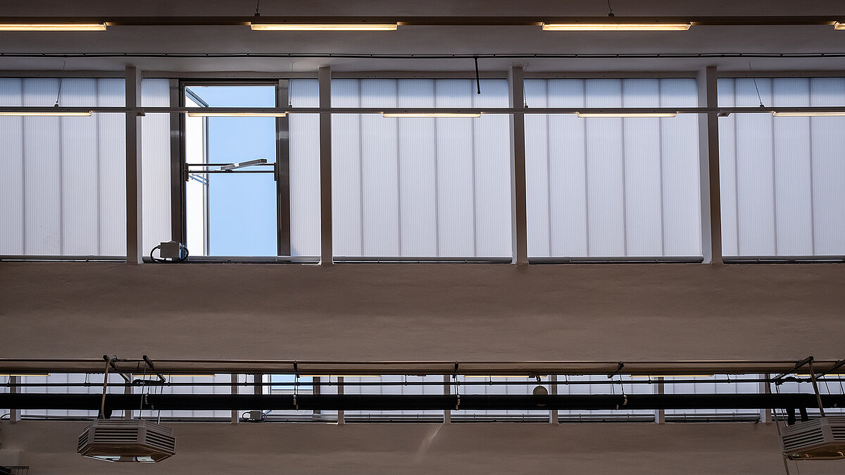 Interior view of the old post station in Leipzig with modernized skylights and open windows for ventilation.