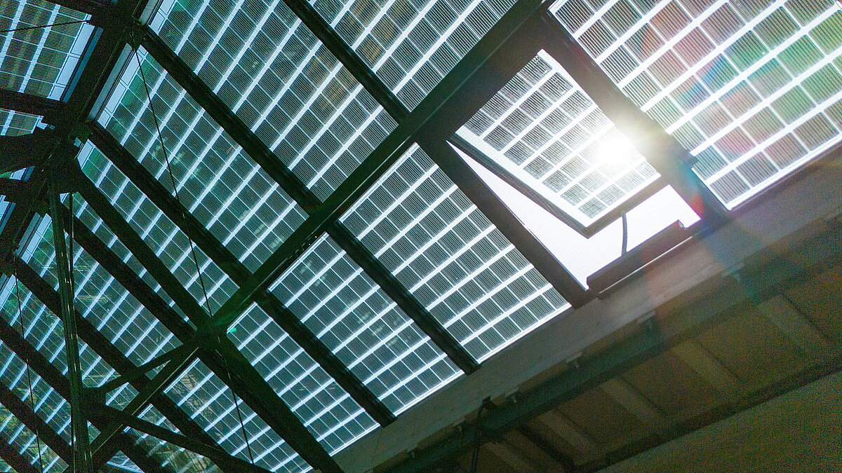 Close-up of an open ventilation element in a LAMILUX glass roof PR60 with integrated PV modules.