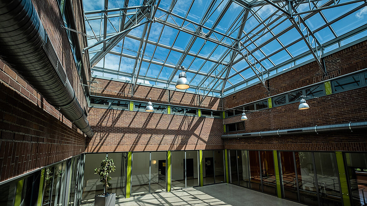 The inner courtyard of a brick building with a modern glass roof.