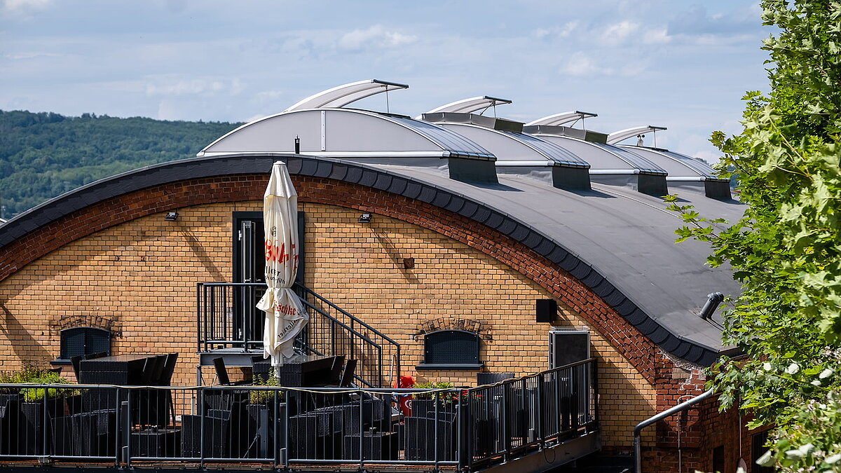 Exterior view of the "Alte Brauerei" climbing hall in Eisenach featuring LAMILUX skylight bands B on the arched roof.