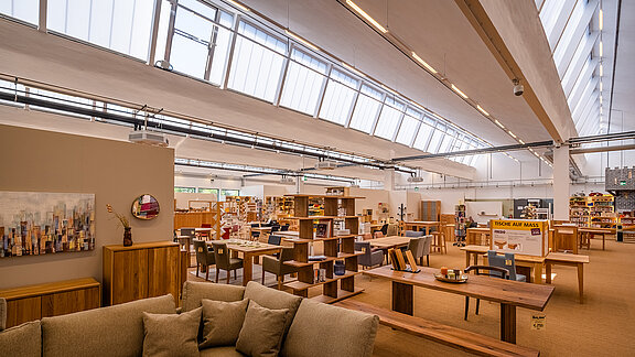  Interior view of the old post station in Leipzig, repurposed as a furniture store with modern design, natural skylights, and stylish furniture.