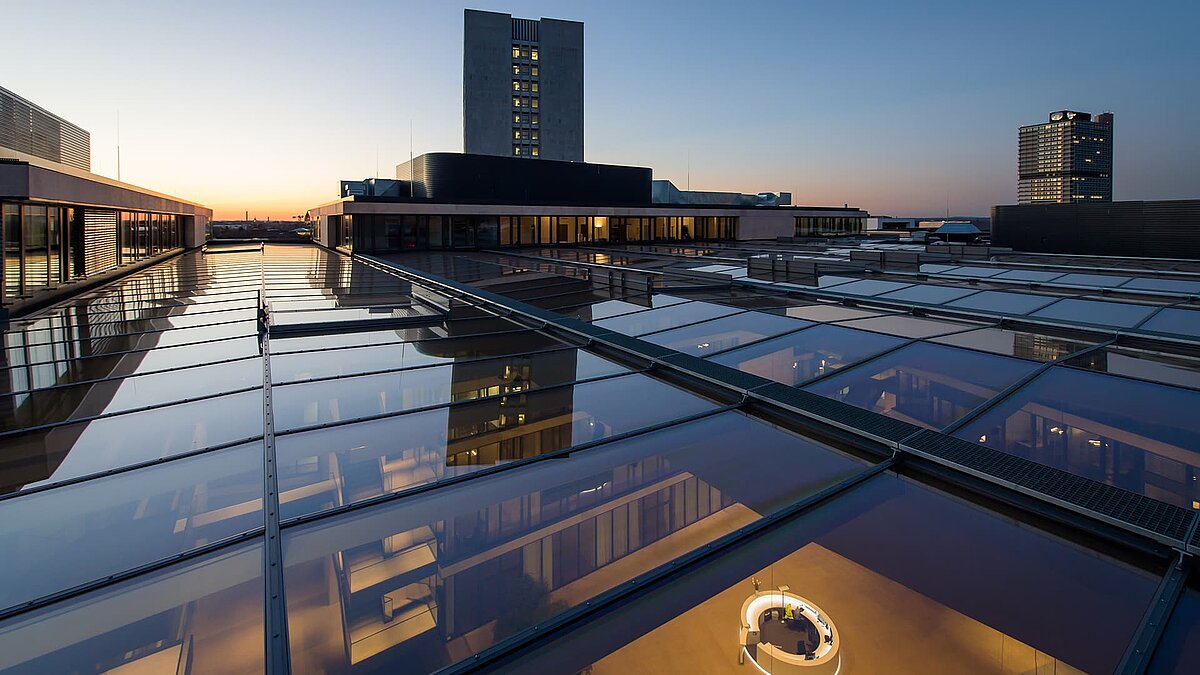 Glass roof at FGS Campus during sunset with reflective glass surfaces and modern building in the background.