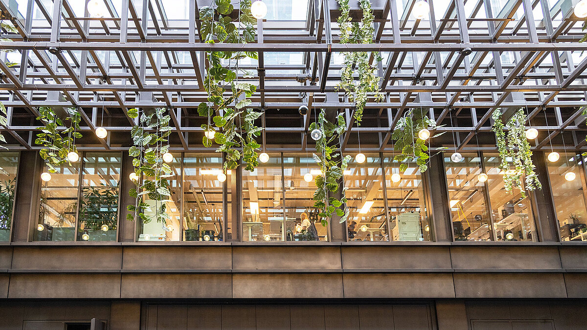 Interior view of Kalle Halle Neukölln with LAMILUX Glass Roof PR60, hanging plants and lighting