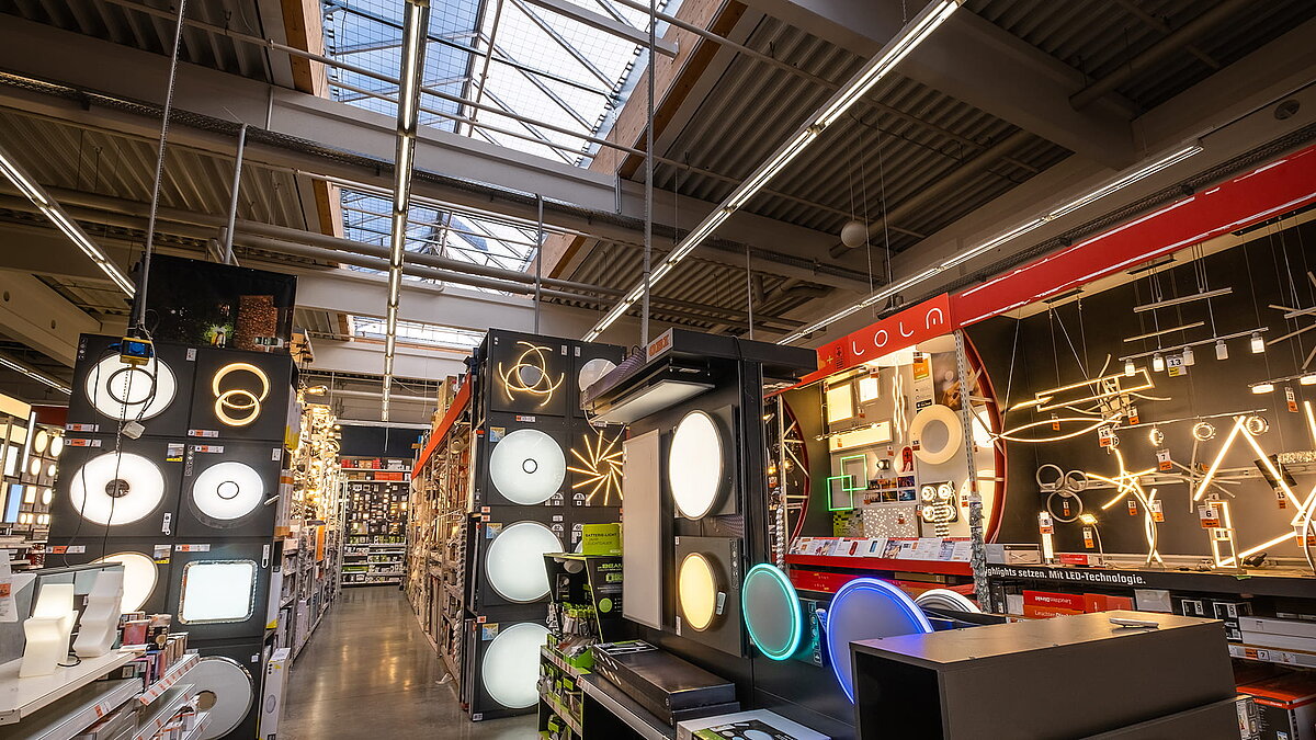 Illuminated lighting section in the OBI hardware store in Bamberg with various lamps and skylights on the ceiling.