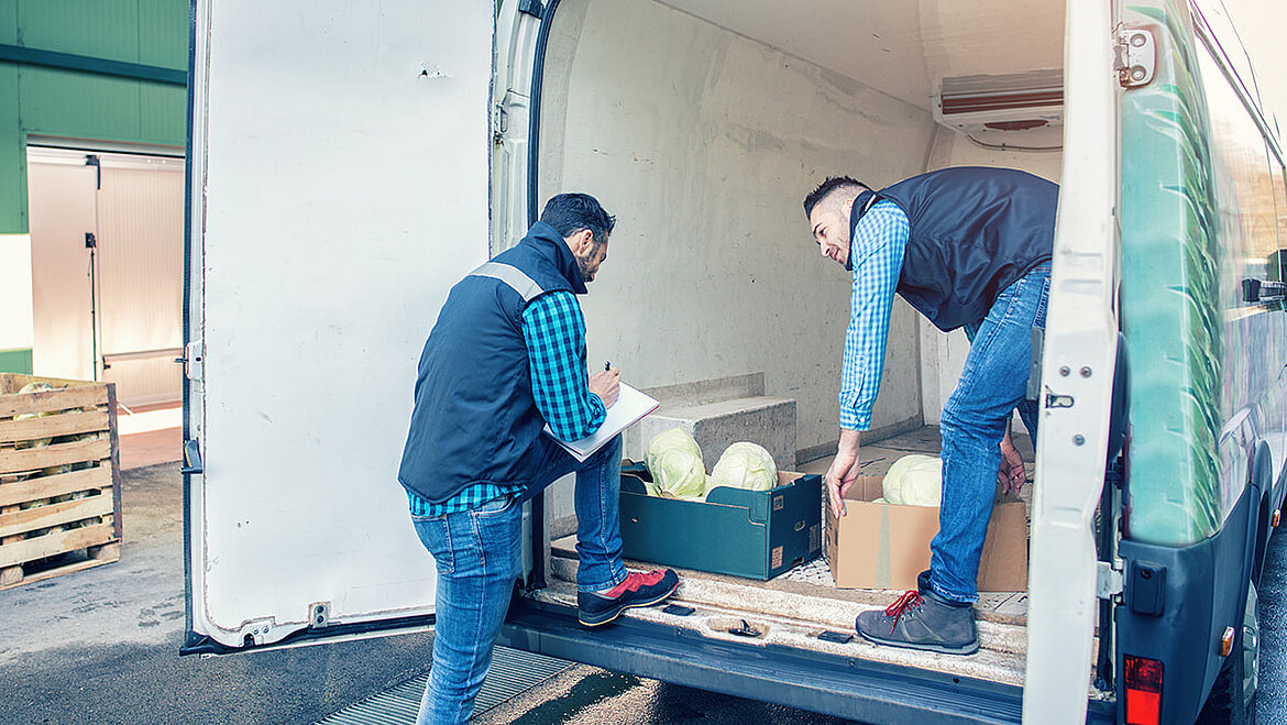 Men loading food transporters Two men loading vegetables onto a van