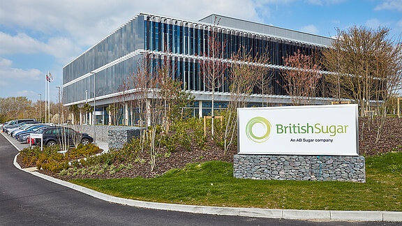 Modern British Sugar office building with glass facade and company sign at the entrance