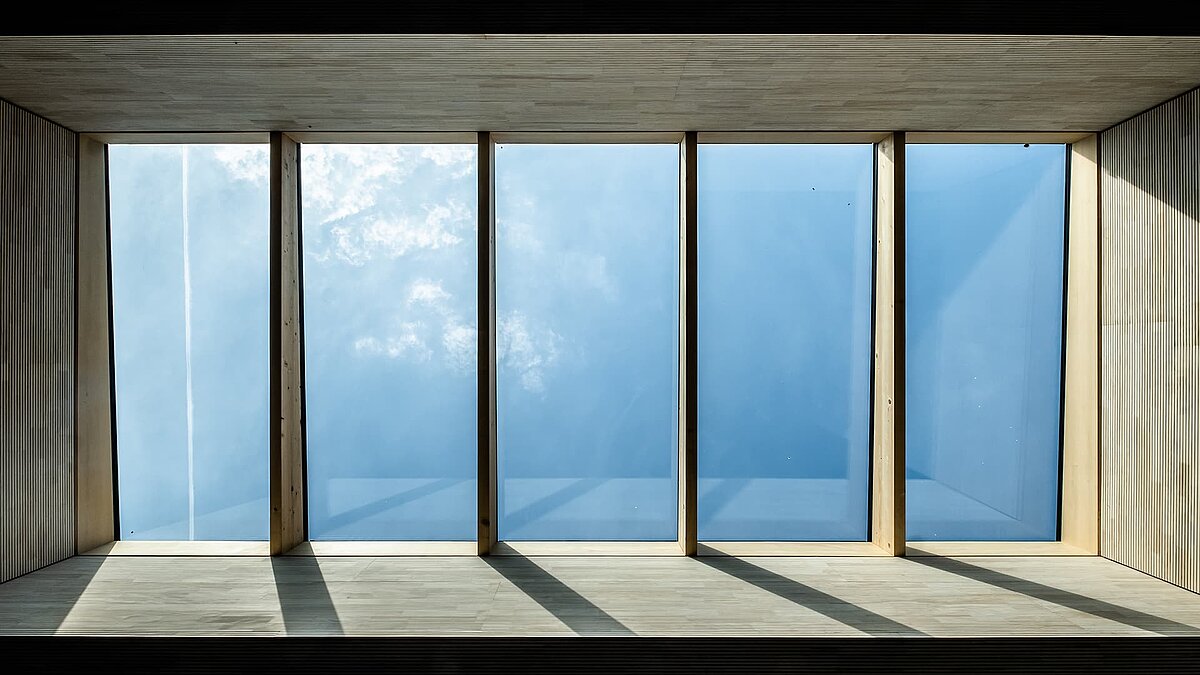 Daylight through large, rectangular skylights in the Wiggensbach crèche, surrounded by wooden panelling.