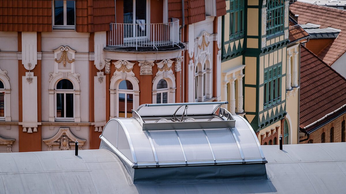 Roof of the "Alte Brauerei" climbing hall in Eisenach with LAMILUX skylight band B, surrounded by historic facades.