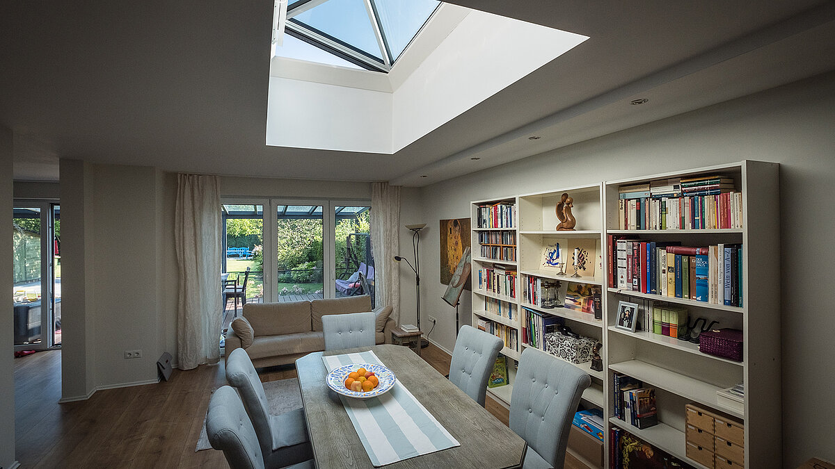 Living room of a residential house in Hamburg with a LAMILUX flat roof window, providing abundant natural light and creating a bright, welcoming atmosphere.