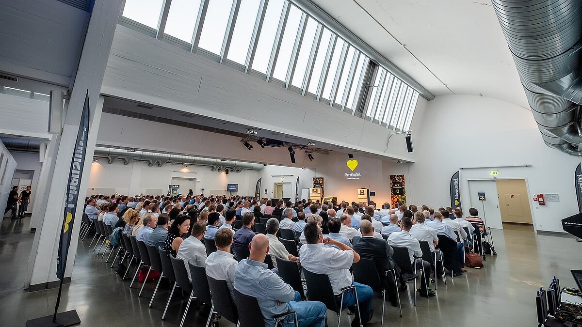 vent at the Vogel Convention Center in Würzburg, with attendees in a hall under a glass roof