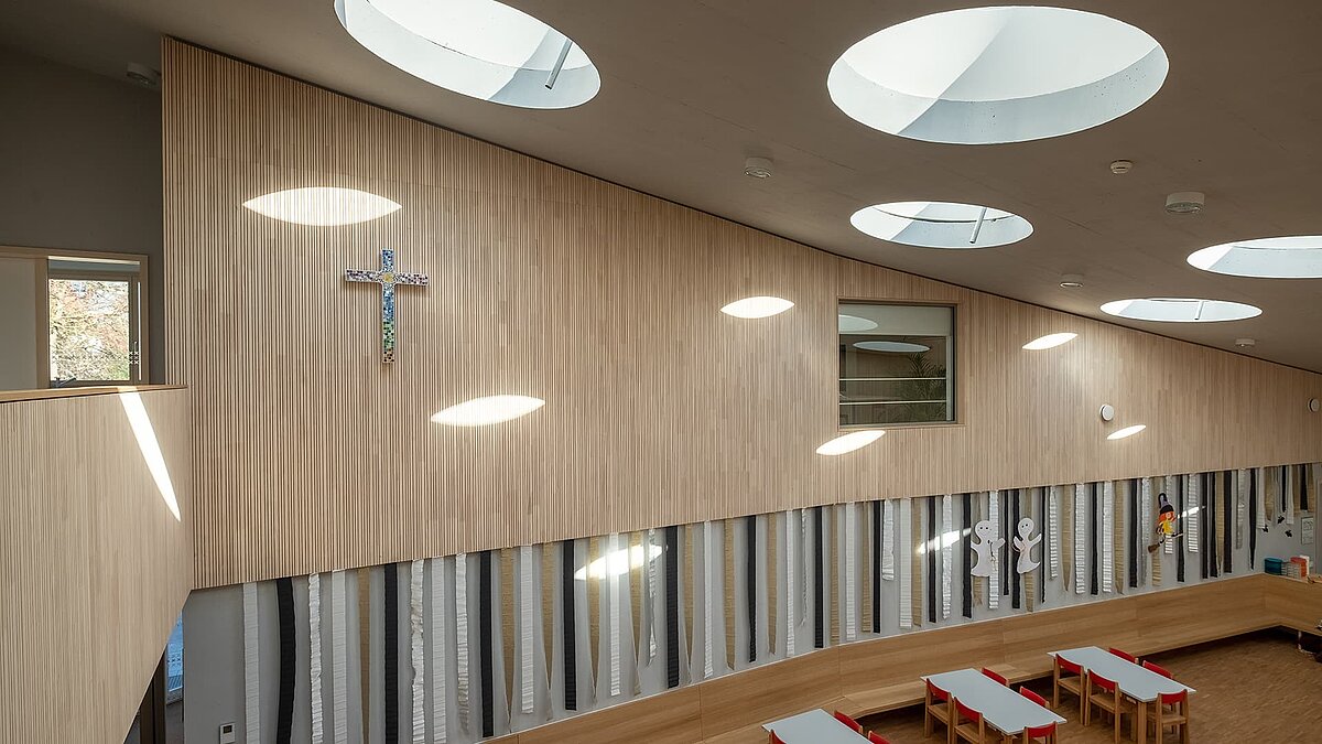 Interior view of St. Severin Kindergarten with round flat roof windows allowing natural daylight to enter.