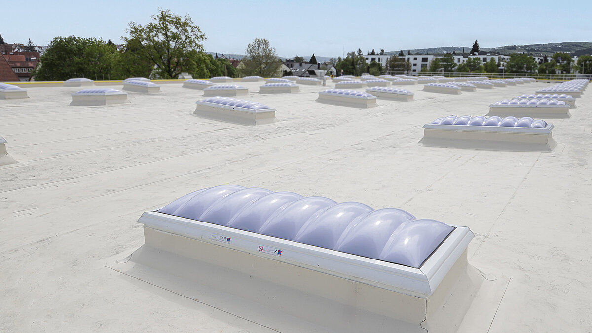 Roof with innovative daylight solutions at Kärcher with dome-shaped skylights for improved safety and efficiency.