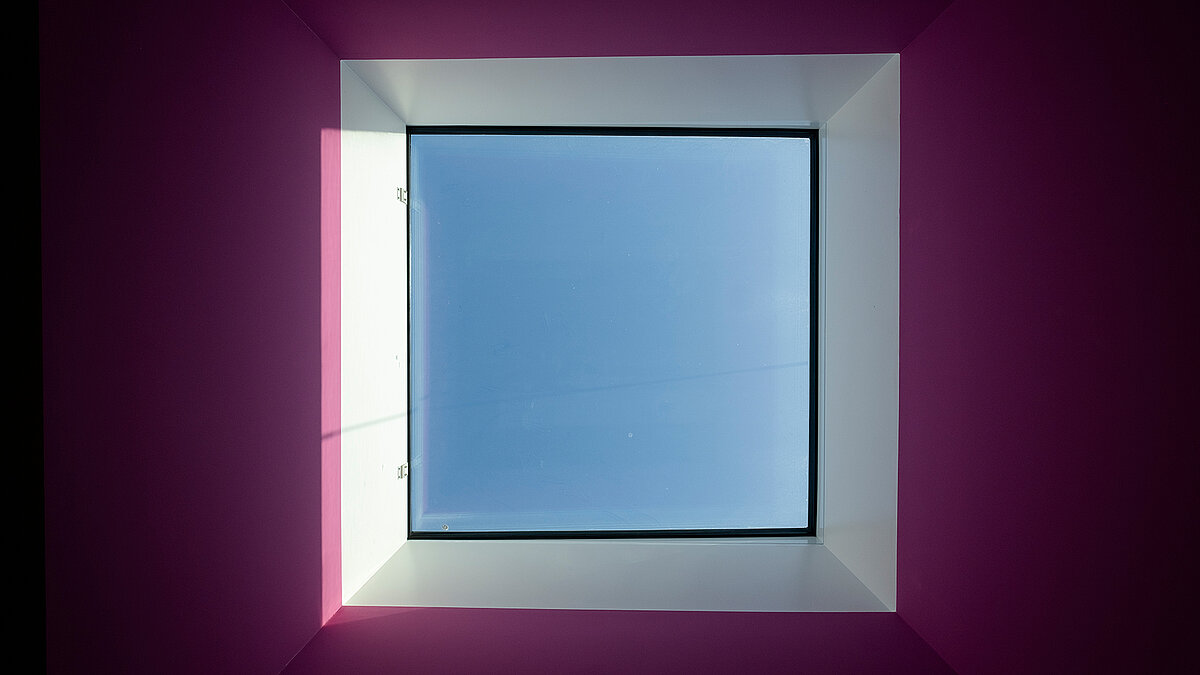 Square-shaped skylight in the "World of Kids" kindergarten featuring LAMILUX daylight systems and purple wall design.