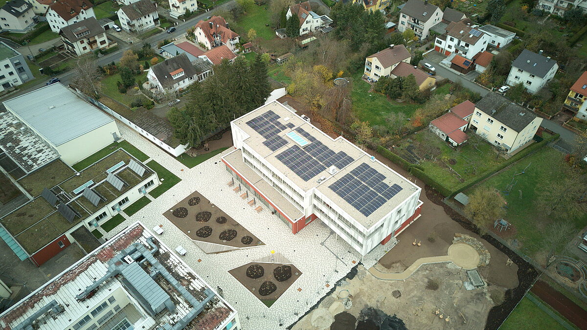Aerial view of Burgebrach school center with LAMILUX glass roof PR60 and solar panels on the roof.