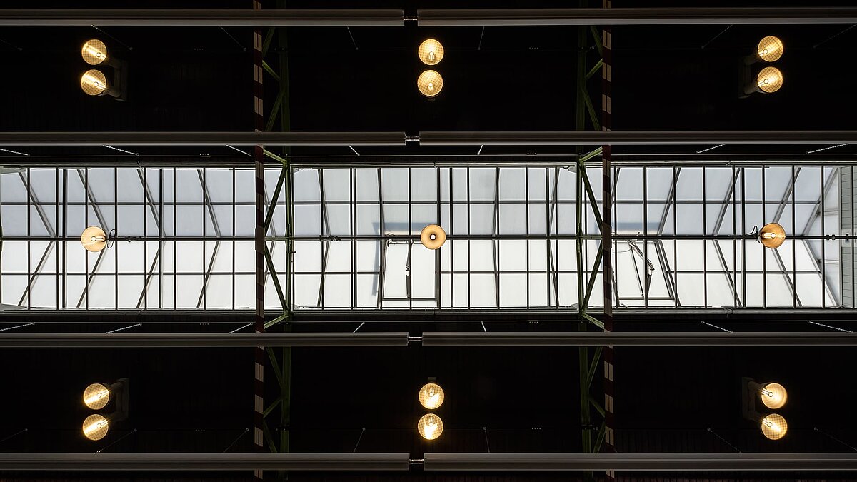 Interior view of the glass roof of the Zündmagnet event hall in Wurzen featuring modern lighting and industrial charm.