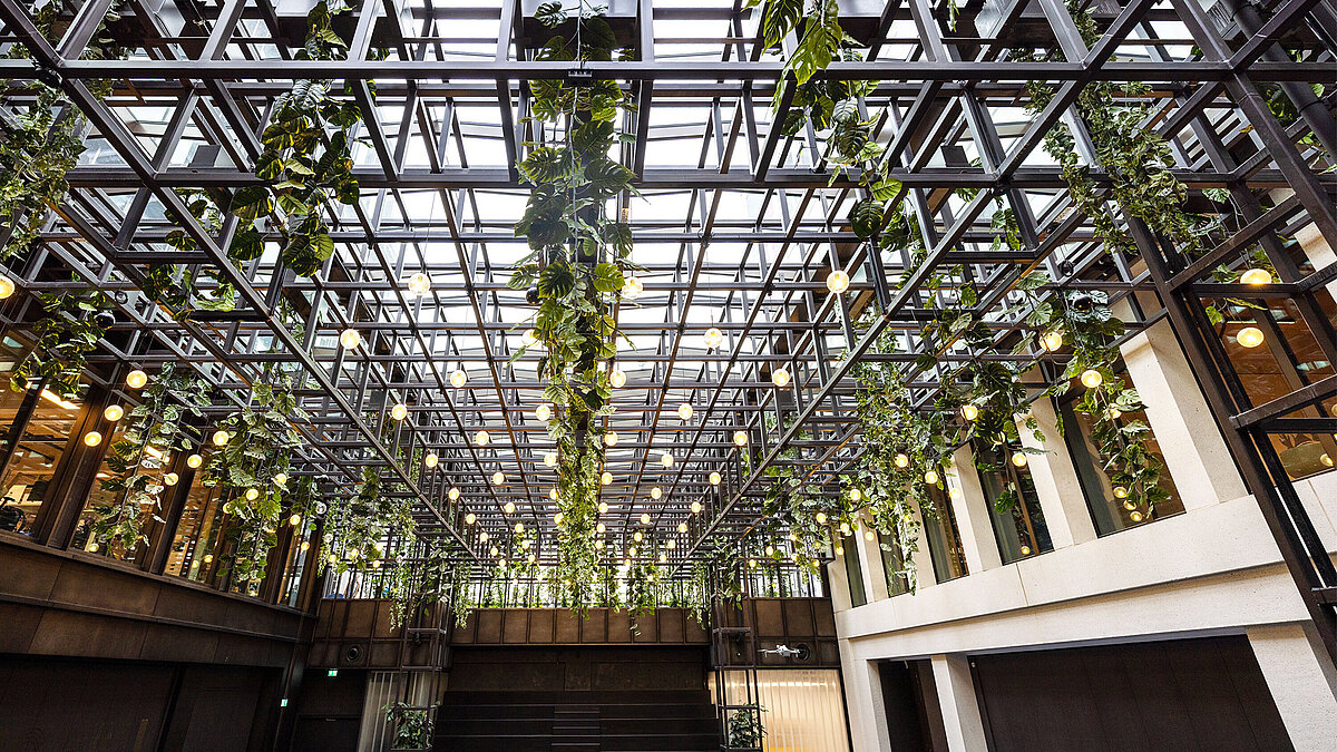 Green atrium of Kalle Halle Neukölln with LAMILUX Glass Roof PR60