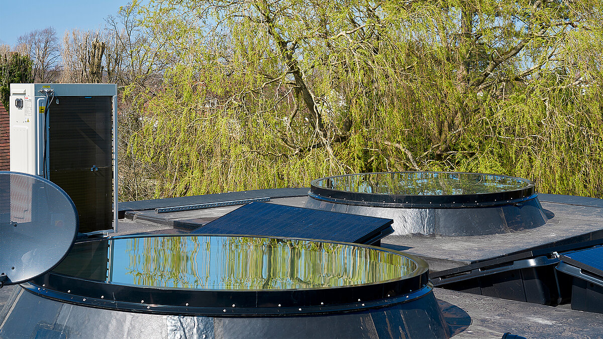 Flat roof with round LAMILUX rooflights and integrated solar modules