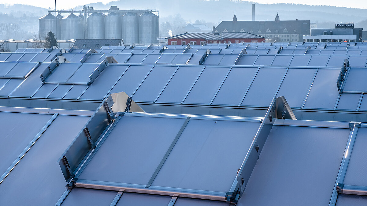 Roof of the OBI hardware store in Bamberg featuring modern skylight panels for natural lighting, with silos and industrial buildings in the background.
