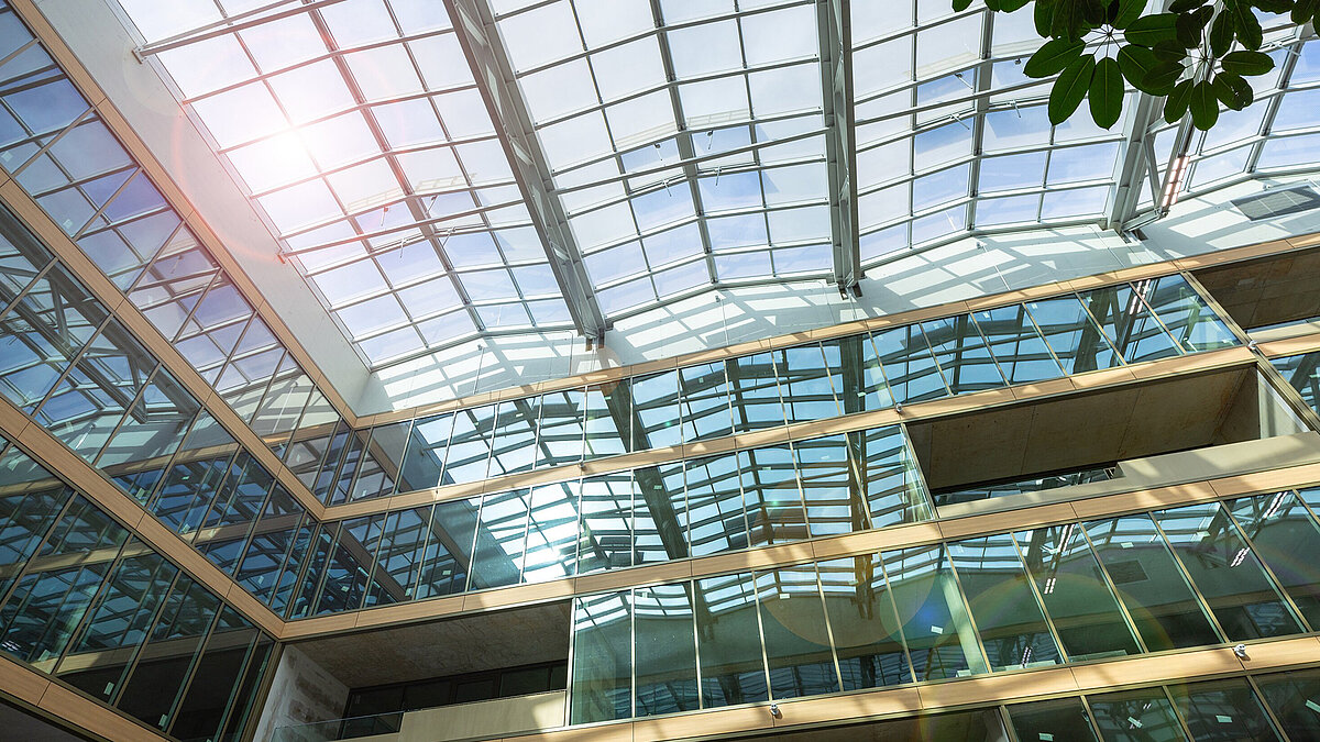 The EUREF Campus Düsseldorf, featuring a glass roof, a modern façade, and a view of the blue sky