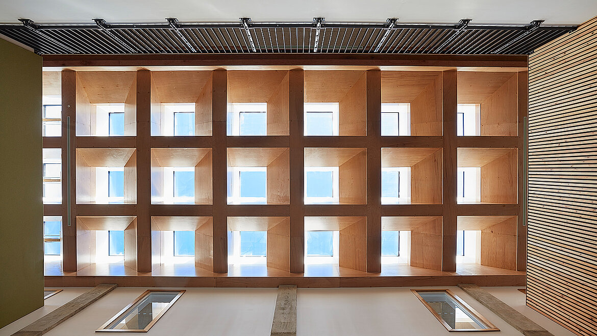 Ceiling with square skylights in wooden frames and artistic wall patterns.