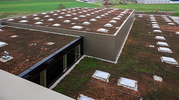 Exterior view of the roof of the Zaltech building in Moosdorf, Austria, with LAMILUX F100 flat roof windows and FE round flat roof windows.