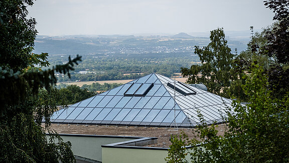 Exterior view of the glass roof at Neuwied Zoo with PR60 construction surrounded by trees with a view of the landscape.