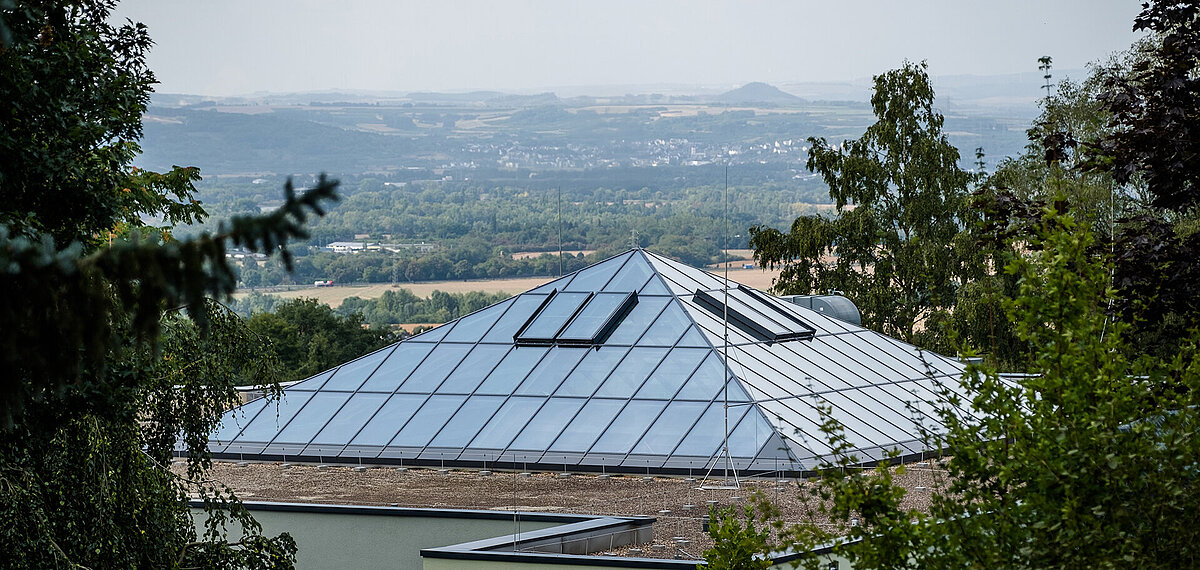 Exterior view of the glass roof at Neuwied Zoo with PR60 construction surrounded by trees with a view of the landscape.