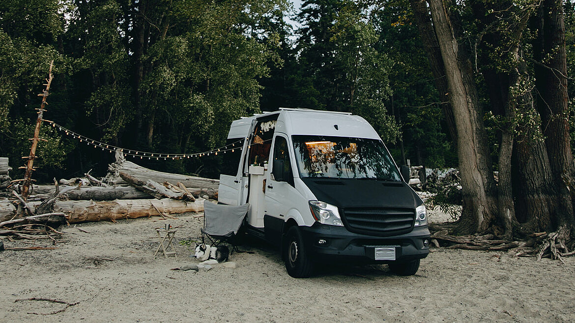 Camper van on the beach with fairy lights