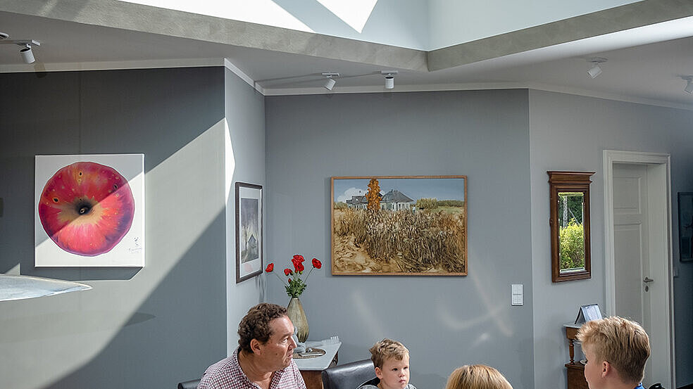 Family dining under a modern glass pyramid in the new single-family home in Wichmannsdorf.