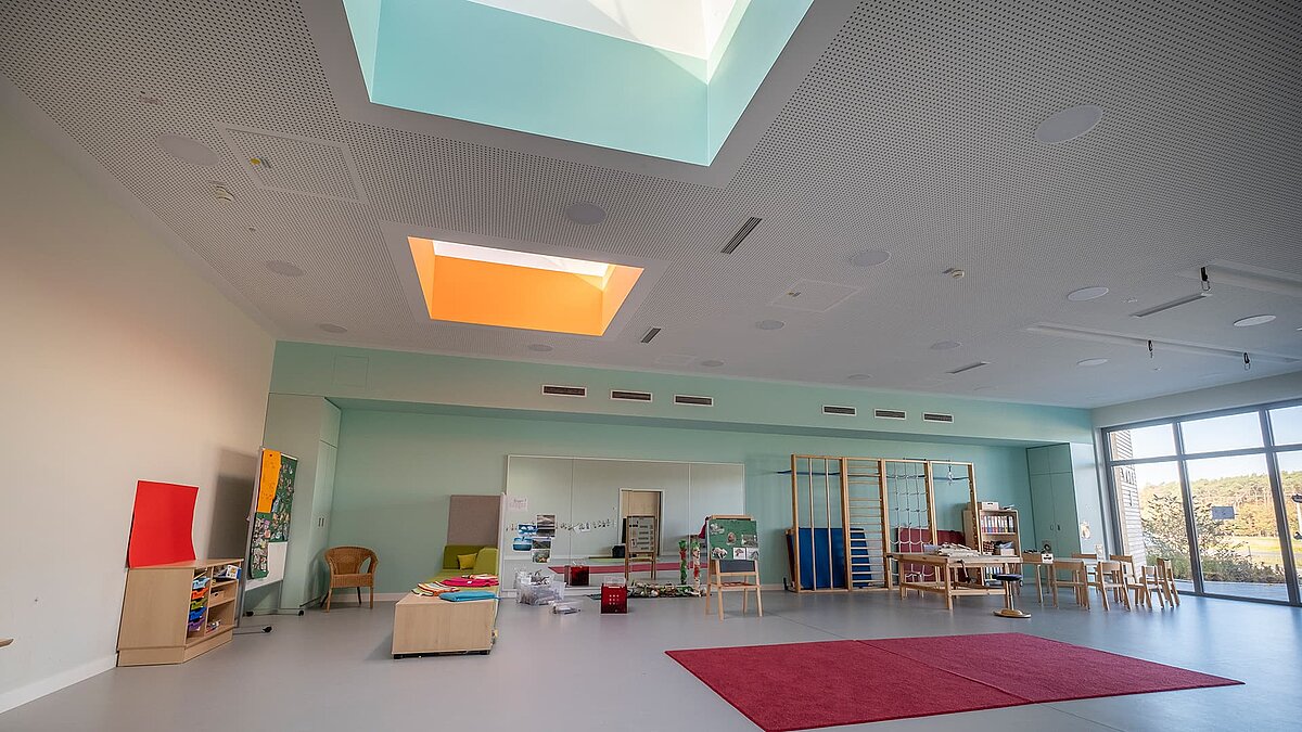 Group room in the "World of Kids" kindergarten featuring LAMILUX flat roof window FE 3° and PR60 glass roof, providing natural light.