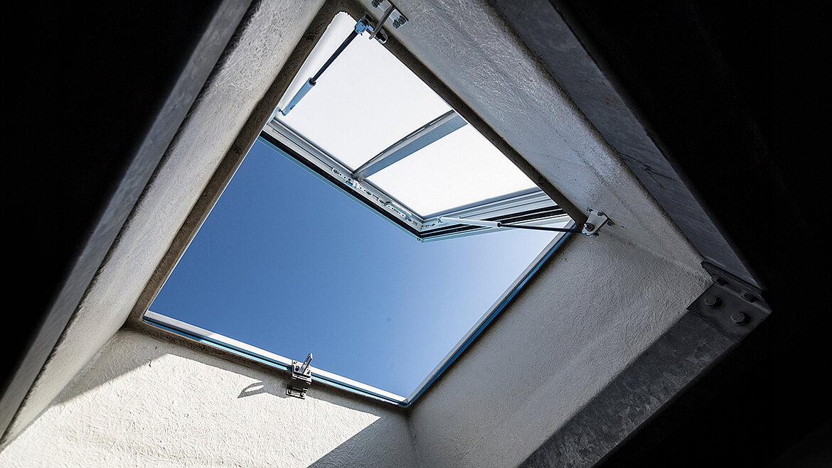 An open skylight with a view of the blue sky