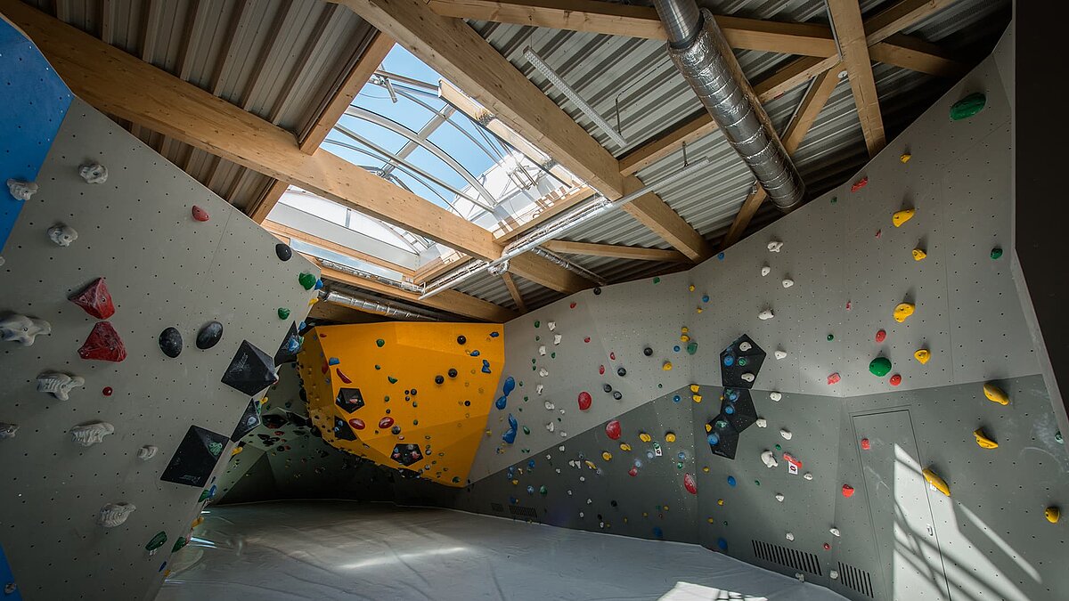 Climbing hall at OWL climbing center featuring colorful climbing walls and a large skylight for natural daylight.