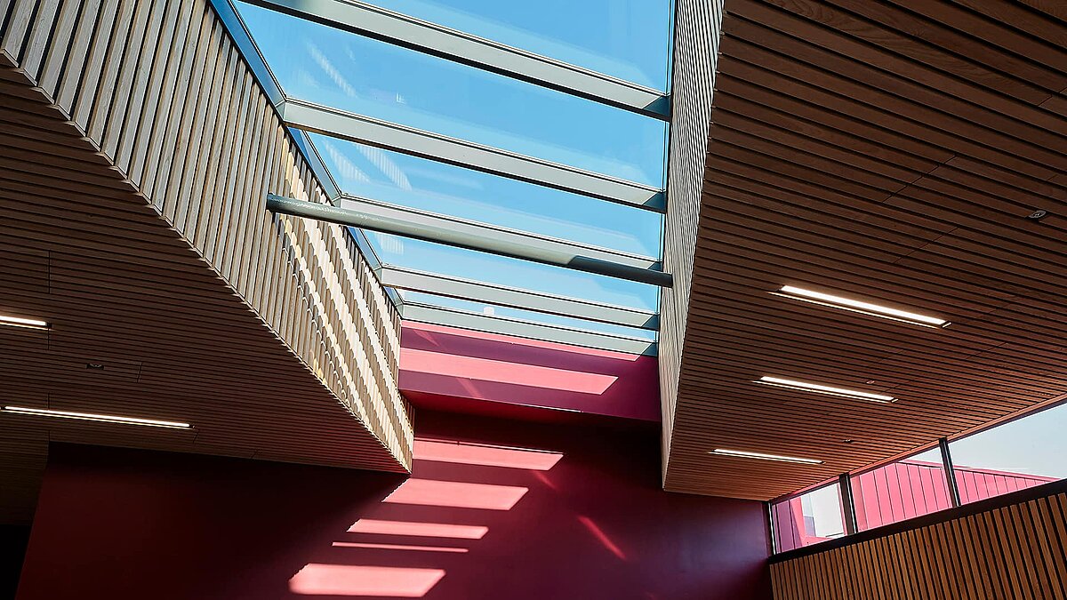 Interior view of Sheffield Hallam University featuring LAMILUX PR60 glass roof and modern wooden ceilings.