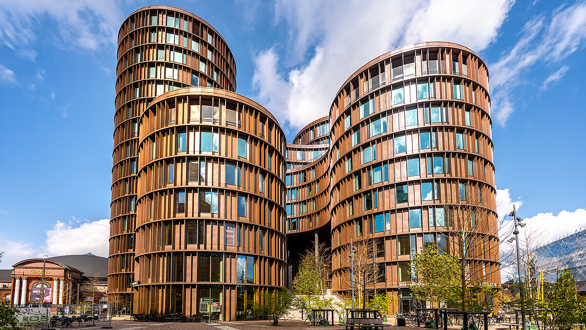 Modern residential buildings with curved facades and large windows under a blue sky