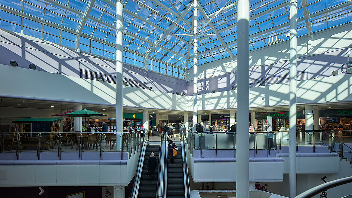 A large glass roof over the atrium of a shopping centre.