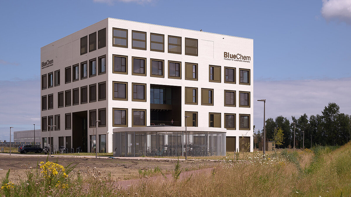 Modern office building with light-colored facade, large windows and central entrance