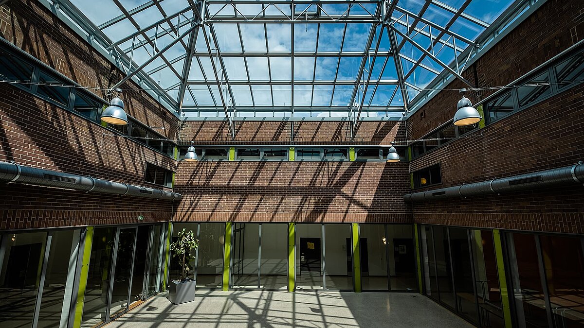 Interior view of the Dante-Gymnasium featuring a large glass roof.