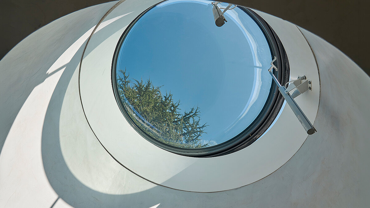 Close-up of a round LAMILUX rooflight with opened sash