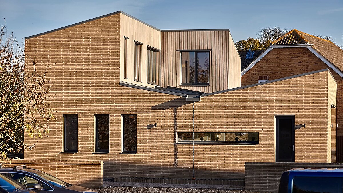 Modern Potton Show Homes building in England featuring a wood and brick facade with large windows.