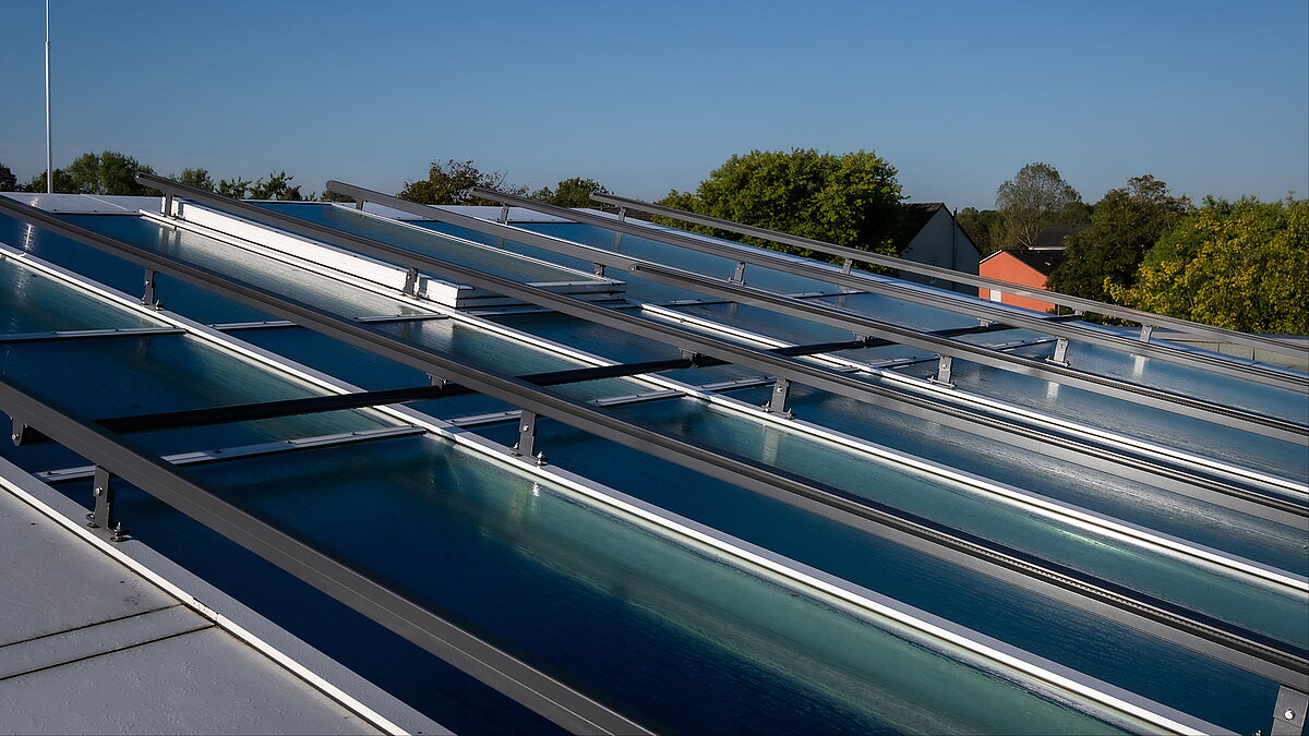 Roof view of the Bertha-von-Suttner Realschule in Cologne featuring modern daylight systems and glass surfaces.