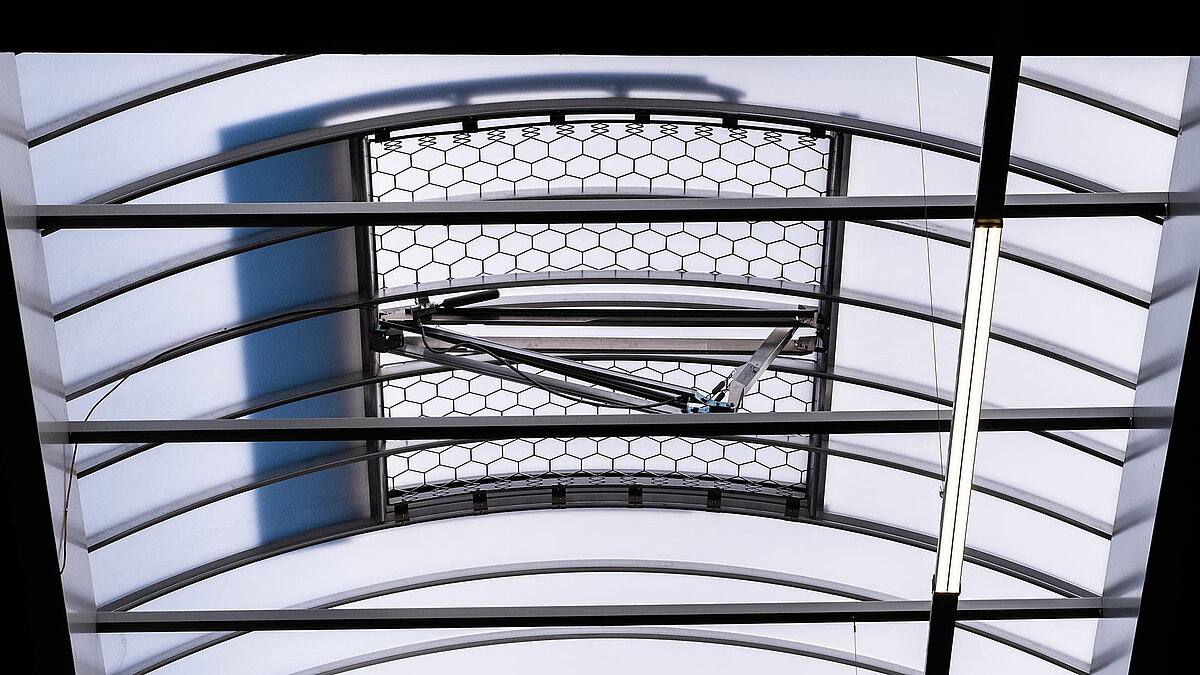 Close-up of a LAMILUX F100 W skylight with integrated ventilation mechanism in the production hall of the Unglehrt construction company.