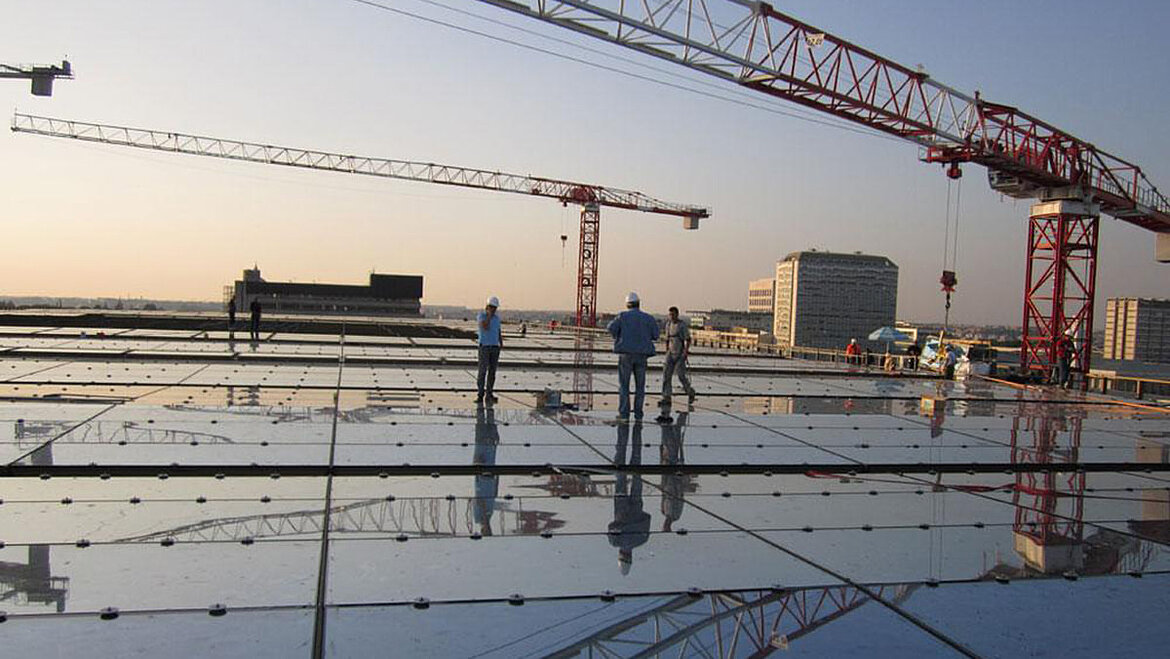 Glass roof with crane and construction workers Glass roof of the Nuovo Centro Congressi during the construction phase | insights by LAMILUX